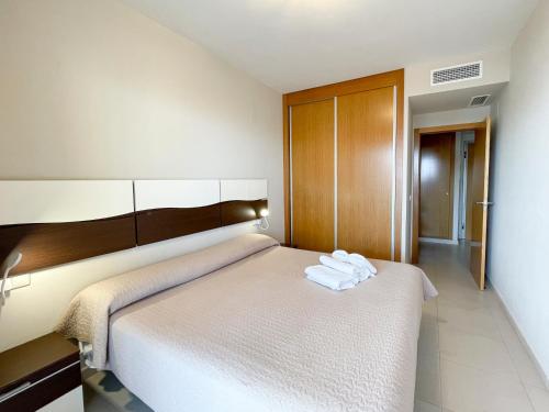 a hotel room with a bed with towels on it at Apartamentos Entremares - Grupo Antonio Perles in Calpe