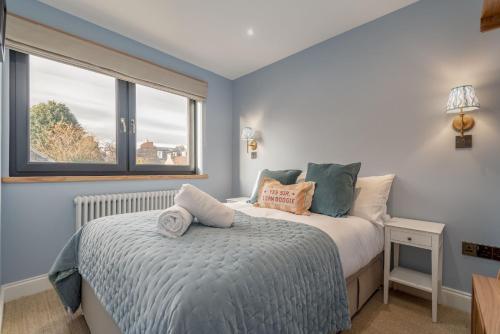 a bedroom with a bed and a window at Logies Cottage in St. Andrews