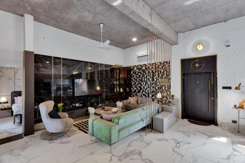 a living room with a couch and a table at SaffronStays Dew Drops in Dhamni