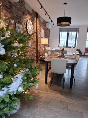 a christmas tree in a living room with a table at Un gîte sous roche in La-Roche-en-Ardenne