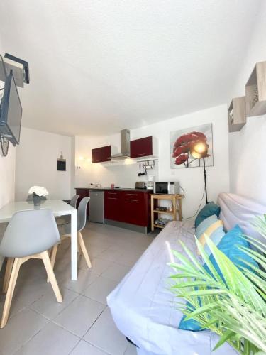 un salon avec une table et une cuisine dans l'établissement Maisonnette Ultra cosy Bord de mer Terrasse, à Guidel