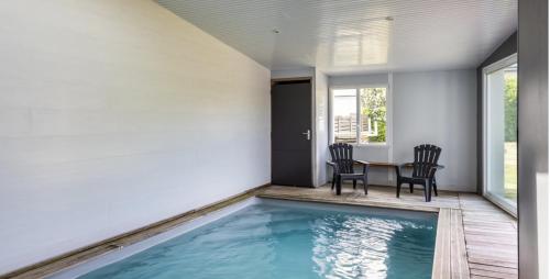 - un coin repas avec une table et des chaises à côté de la piscine dans l'établissement Villa les Ebihens piscine intérieure 14 personnes, à Saint-Cast-le-Guildo