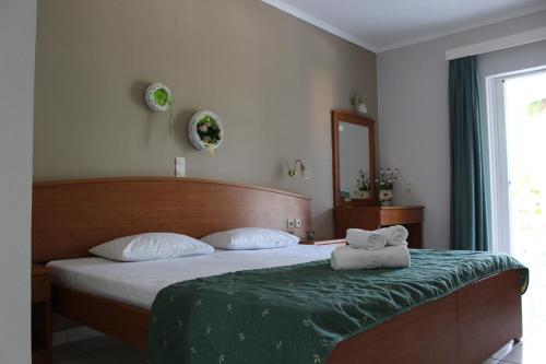 una camera da letto con un letto con un piumone verde di Smile's Studios a Tsilivi