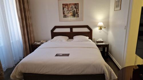 a bedroom with a large bed with white sheets at Hotel Du Parc - Mulhouse Centre in Mulhouse