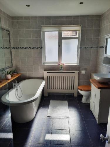 a bathroom with a tub and a toilet and a sink at Super king bedroom with large ensuite in Brighton & Hove