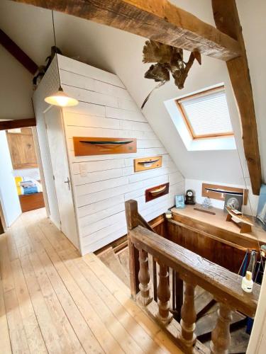 Cette chambre mansardée comprend une table et un banc. dans l'établissement Appartement de charme Cosy À 2 pas des plages, à Larmor-Plage