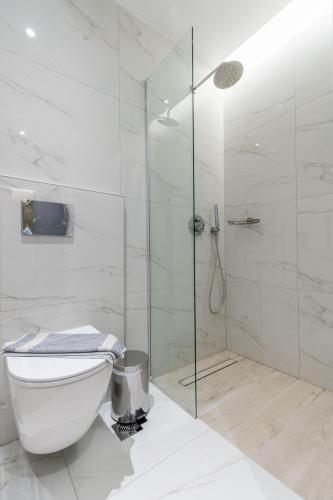 a bathroom with a toilet and a glass shower at Sunny Days Hotel in Ixia