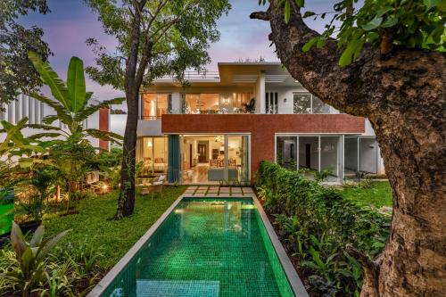 a house with a swimming pool in front of it at La Dora by The Blue Kite -3BHK Contemporary Villas with Pvt Pool, 5 mins Walk to Vagator beach-Caretaker, Kitchen & Garden in Vagator