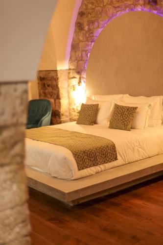 a bedroom with a bed with a stone wall at פינה בראש מלונאות ותיירות in Rosh Pinna
