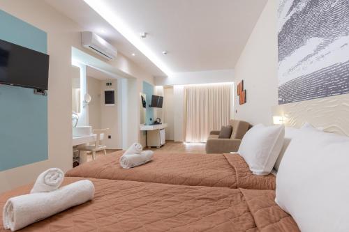 a bedroom with a large bed with towels on it at Sunny Days Hotel in Ixia