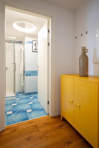 a bathroom with a shower and a yellow cabinet at MoBiRetreat by Klodge in Olbia