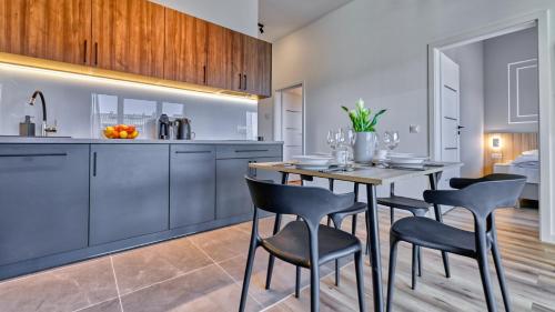 a kitchen and dining room with a table and chairs at Źródło Izery przy gondoli VIP Sauna, Siłownia, Bawialnia by Royal Aparts in Świeradów-Zdrój