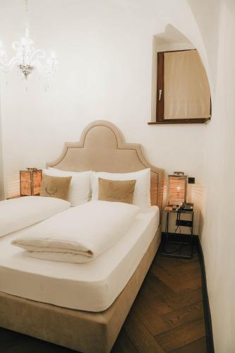 two white beds in a room with a mirror at Boutiquehotel Weisses Rössl in Innsbruck