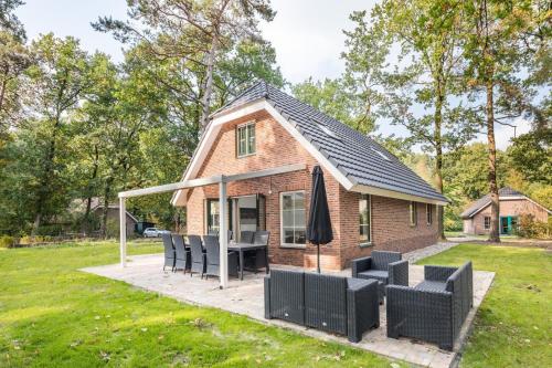 a tiny house with a patio and a table and chairs at Landgoed Het Grote Zand in Hooghalen