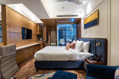 a hotel room with a bed and a tv at The Kleo Hotel in Zirakpur