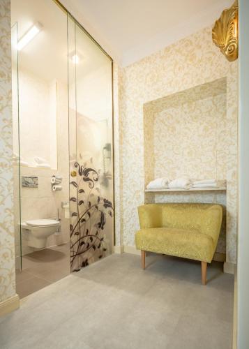 a bathroom with a yellow bench and a shower at Hotel Urania in Vienna