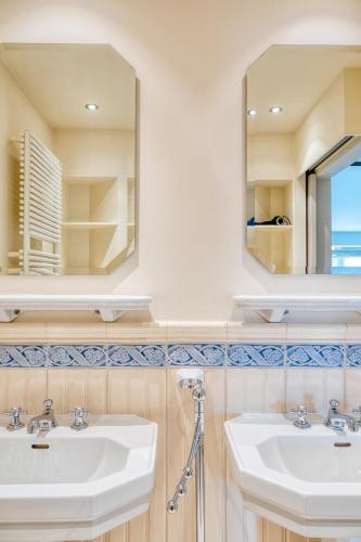 a bathroom with two sinks and a mirror at Stunning 3-Bedroom apartment with panoramic view in De Haan