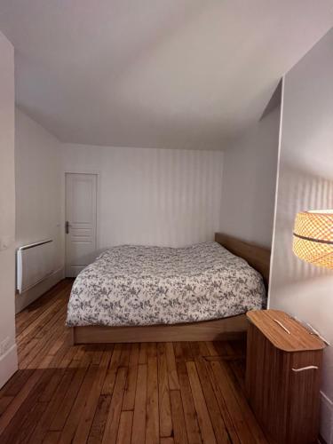 une chambre avec un lit et un parquet dans l'établissement Nid amour Montmartre, à Paris