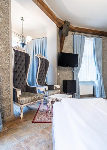 a bedroom with two chairs and a bed at Hotel Urania in Vienna