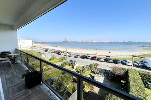 - un balcon avec vue sur la plage et les voitures dans l'établissement Luxury T3 standing 2 - Vue mer exceptionnelle 180, à Larmor-Plage