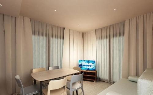 a dining room with a table and chairs and a television at Camping Union Lido in Cavallino-Treporti