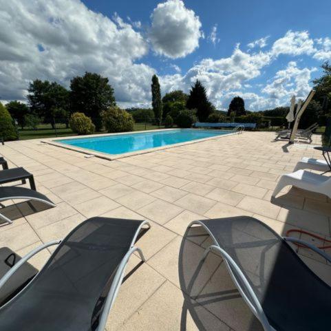 - une piscine avec des chaises dans l'établissement Hameau du Soleil - Renard, à Sainte-Mondane