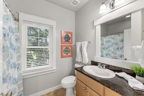 a bathroom with a sink and a toilet and a window at 1369 Laurel Grove "The Crows Nest" in Destin