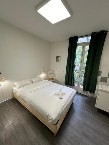 une chambre avec un grand lit et une fenêtre dans l'établissement Maison spacieuse et lumineuse, à Saint-Étienne
