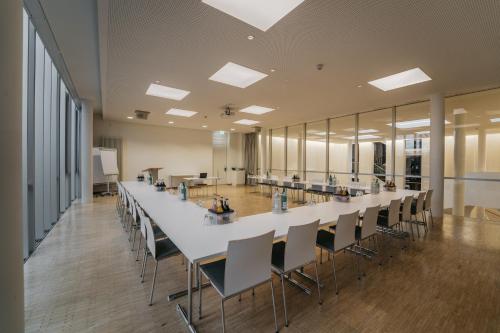 ein großer Konferenzraum mit einem langen Tisch und Stühlen in der Unterkunft Gästehaus Auf dem Heiligen Berg B&B in Wuppertal