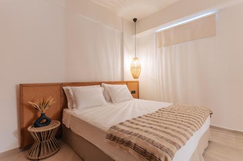 a bedroom with a bed and a vase on a table at Erthā Suites with private pools in Vóthon