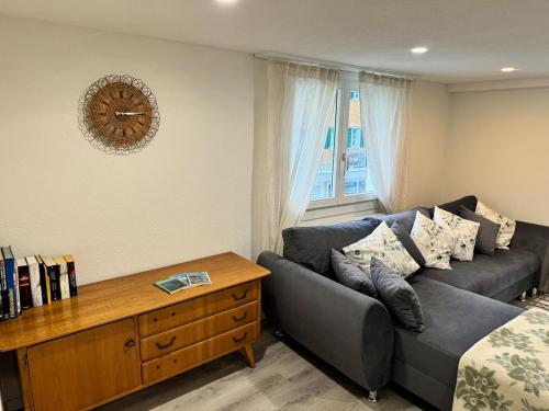 a living room with a couch and a clock on the wall at Bijou N 2 Lungern in Lungern