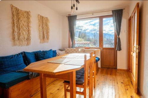 a living room with a table and a blue couch at Cozy Luxurious Apartment Next to Borovets and Rila mountain in Govedartsi