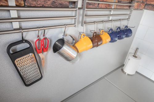 a bunch of utensils are hanging on a wall at Cozy Luxurious Apartment Next to Borovets and Rila mountain in Govedartsi