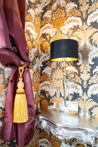 a room with a table with a lamp and wallpaper at Hotel Urania in Vienna