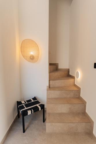 a staircase in a house with a bench next to it at Erthā Suites with private pools in Vóthon