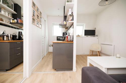 Il comprend une petite cuisine et un salon avec une table. dans l'établissement Charmant studio près de Montmartre, à Paris