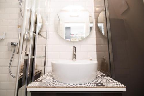 une salle de bain avec un lavabo et un miroir dans l'établissement Charmant studio près de Montmartre, à Paris