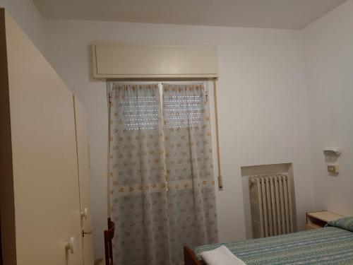 a bedroom with a shower curtain and a bed at Hotel Toschi in Lido di Classe