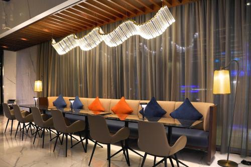 a long dining room with a long table and chairs at Millennium Al Masar in Jeddah