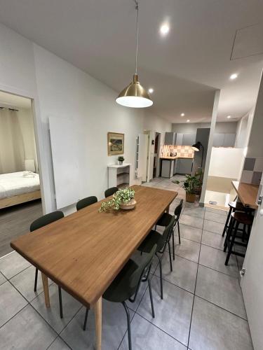 une salle à manger avec une table et des chaises en bois dans l'établissement Maison spacieuse et lumineuse, à Saint-Étienne