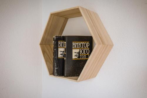 a group of books in a wooden book shelf at Cozy Luxurious Apartment Next to Borovets and Rila mountain in Govedartsi
