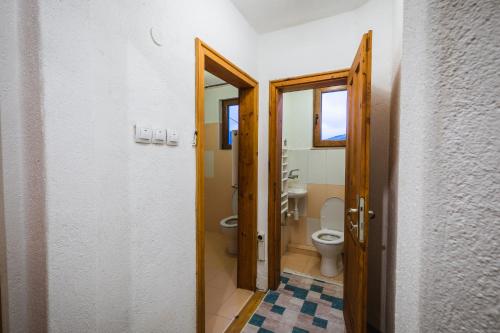 a bathroom with a toilet and a window and two doors at Cozy Luxurious Apartment Next to Borovets and Rila mountain in Govedartsi