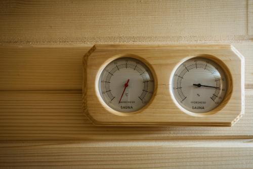 two clocks are on a wooden wall at Cozy Luxurious Apartment Next to Borovets and Rila mountain in Govedartsi