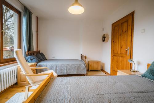 a bedroom with two beds and a chair and a window at Cozy Luxurious Apartment Next to Borovets and Rila mountain in Govedartsi