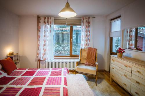 a bedroom with a bed and a chair and a window at Cozy Luxurious Apartment Next to Borovets and Rila mountain in Govedartsi