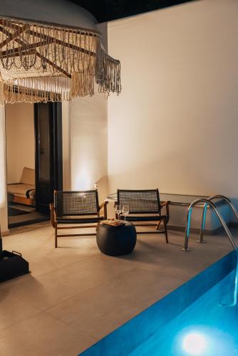 a swimming pool with two benches and a swimming pool at Erthā Suites with private pools in Vóthon