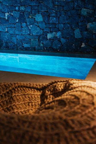 a close up of a brick wall with a reflection at Erthā Suites with private pools in Vóthon