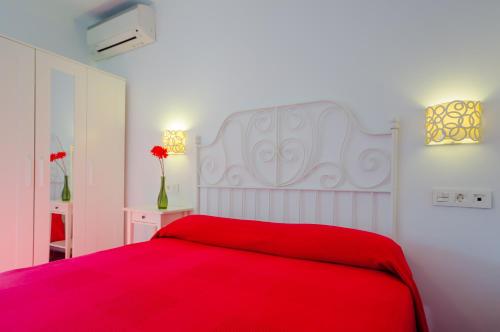 um quarto com uma cama vermelha e um cobertor vermelho em Apartamento Junquera em Conil de la Frontera