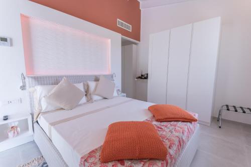 a bedroom with a large white bed with white pillows at Capo Norax chambre de luxe avec jacuzzi à 250m de la mer in Pula