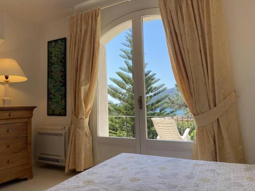 une chambre avec un lit et une grande fenêtre dans l'établissement Appartement vue mer avec accès privé à la plage, à Lecci